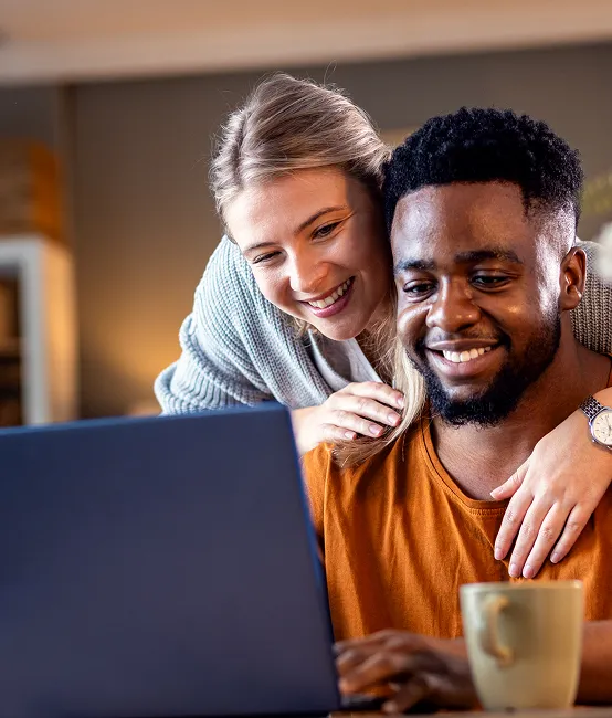 Couple souriant en trouvant les solutions à leur projet de financement