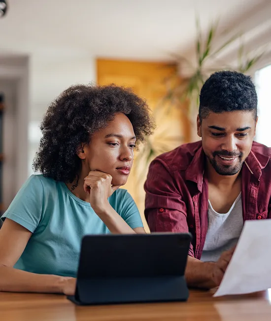 Couple finalisant une demande de consolidation de dettes sur tablette